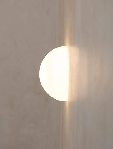 Una luz esférica sobre una pared de tono arena